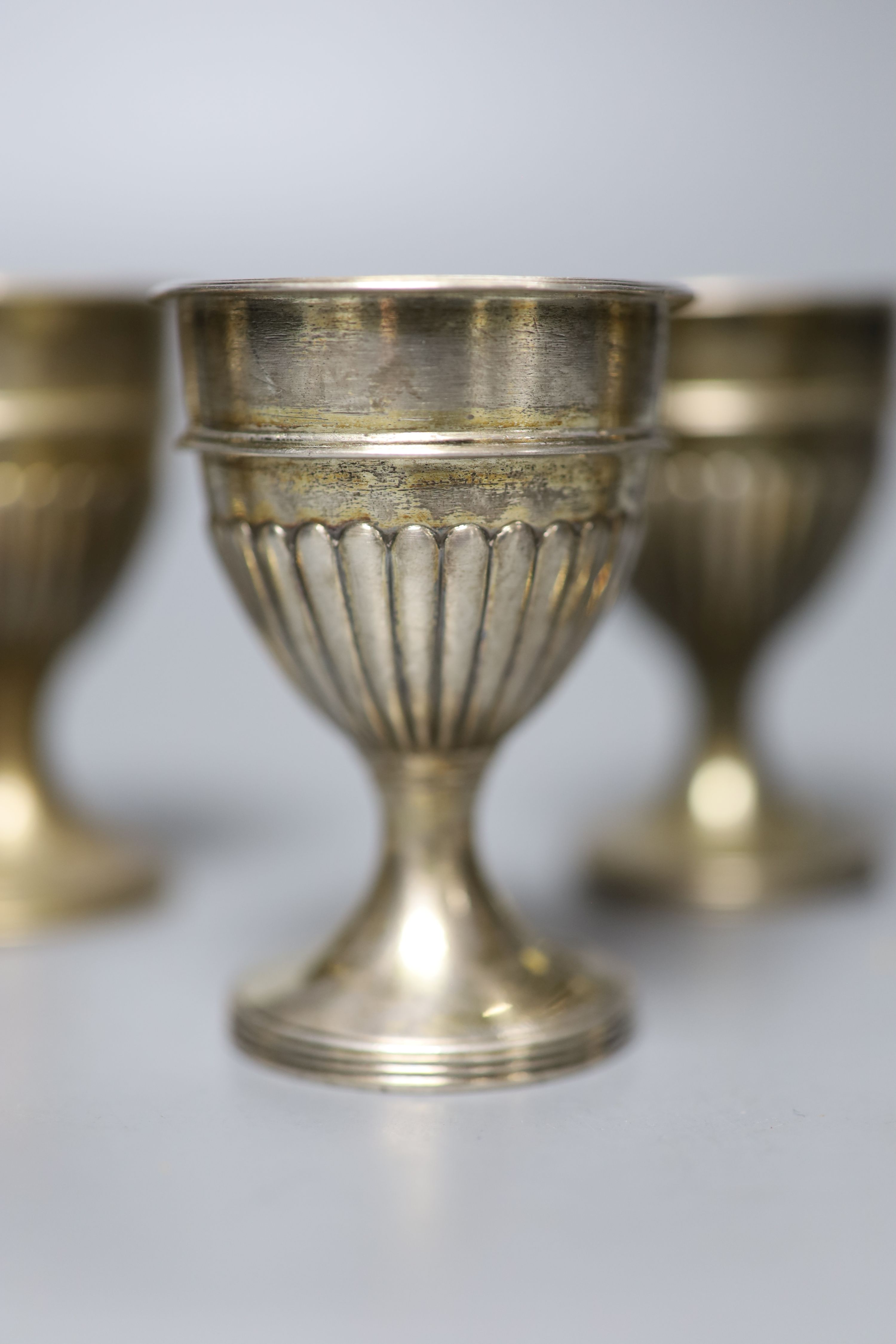 A set of six George III demi-fluted silver egg cups, John Scofield, London, 1797, height 7cm, 9oz.